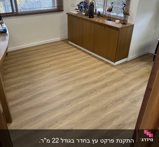 רצפת פרקט עץ בהירה בחדר עם חלונות
